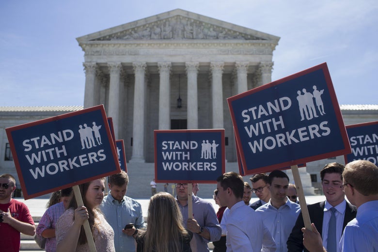 Demonstrators hold signs in front of the U.S. Supreme Court on June 25, 2018 in Washington, D.C.